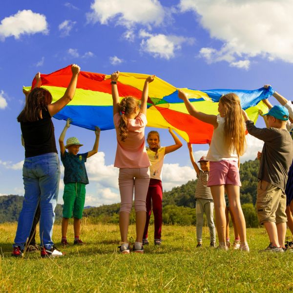 bambini che giocano con telo colorato
