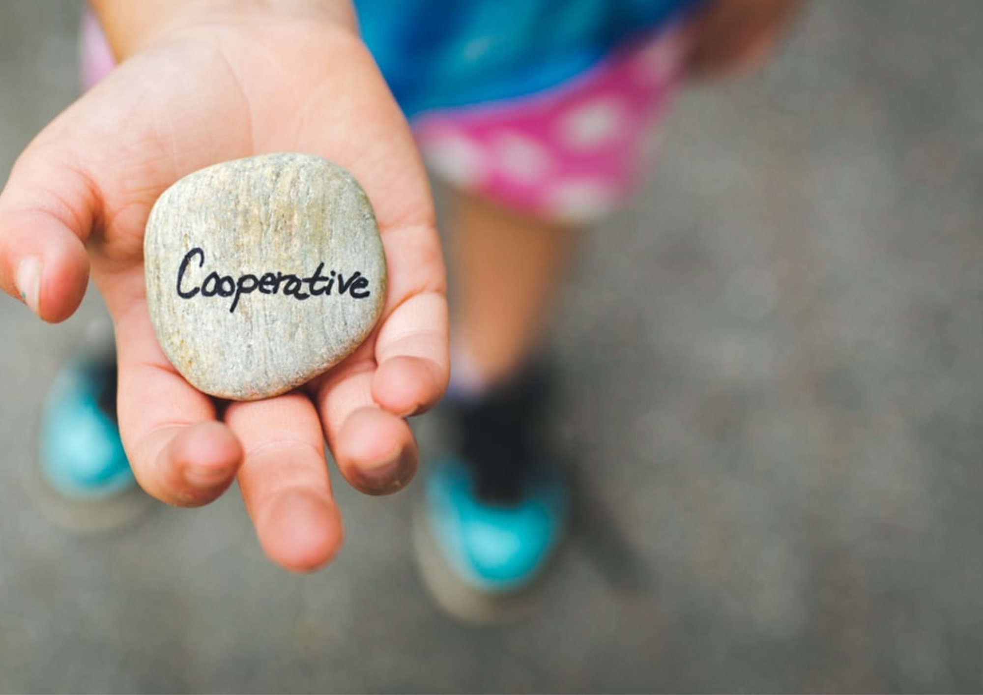 bambino con in mano un sasso con scritto cooperative